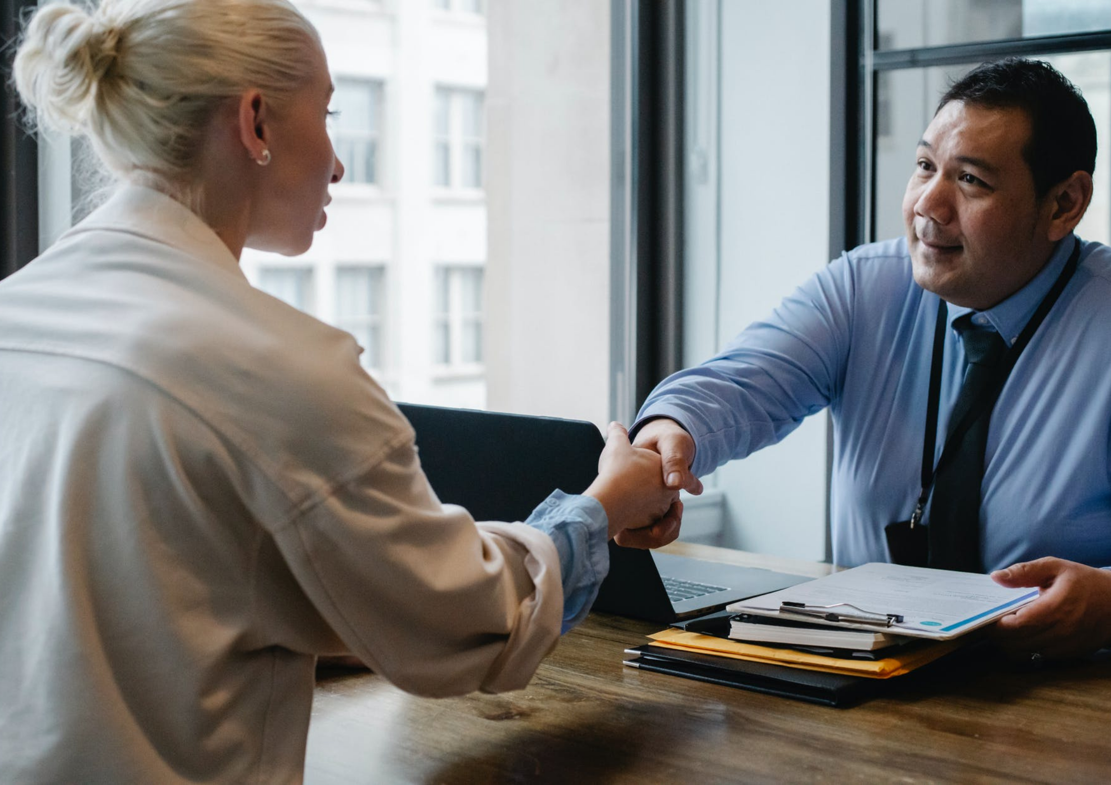 Senior employee shaking hands with another staff member