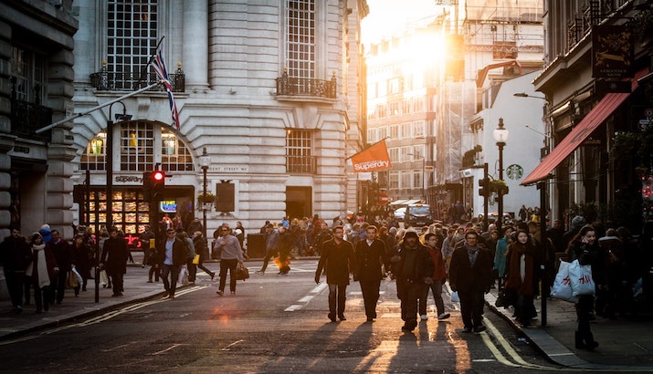 People walking on a road in London at sunset