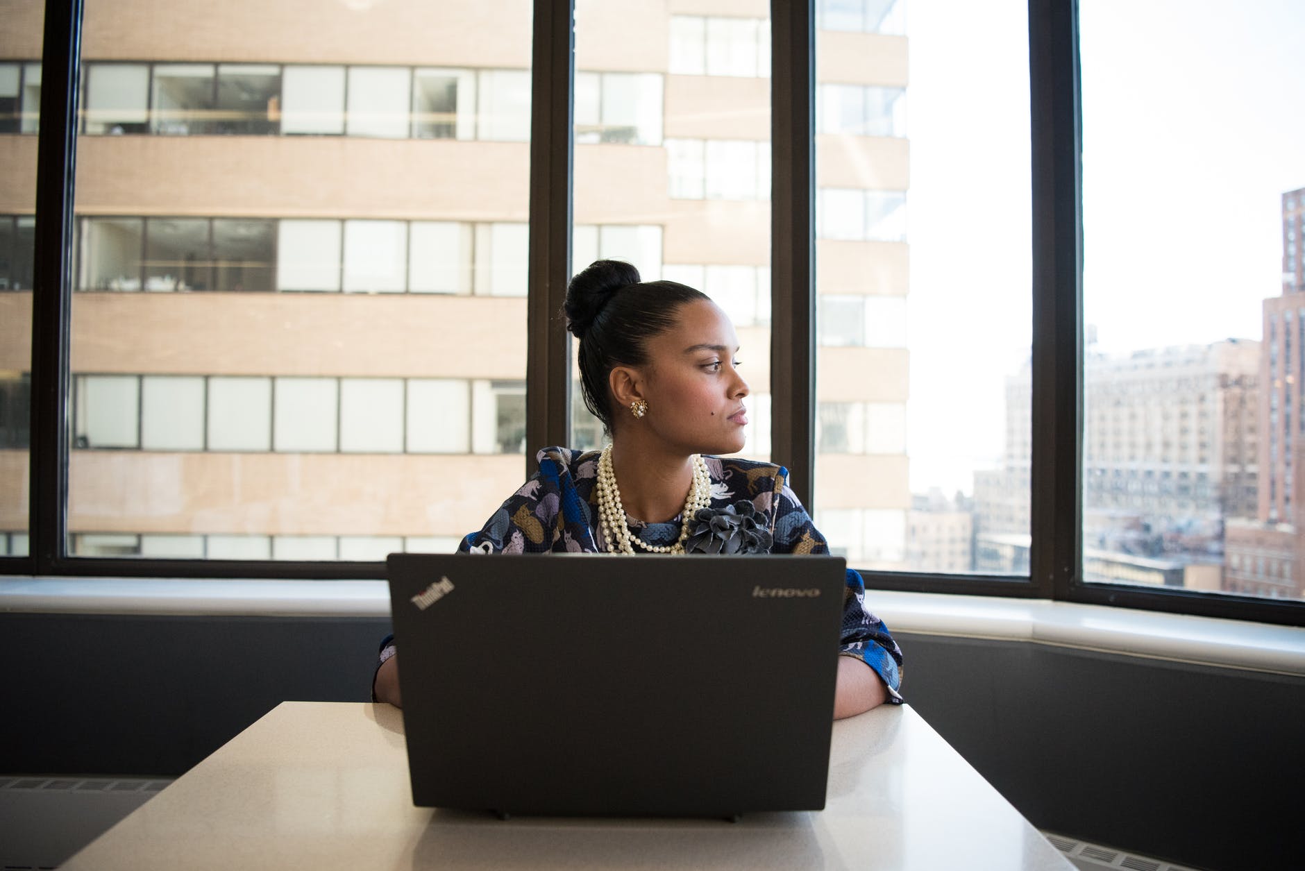 Woman on laptop looking outside office window