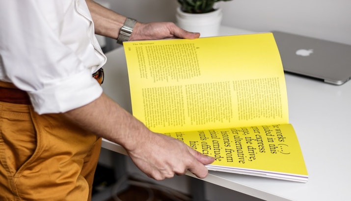 Man reading a yellow magazine